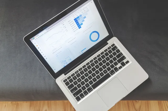 Overhead view of a laptop showing data visualizations and charts on its screen. Programmatic advertising mistakes: the traps and the way around them